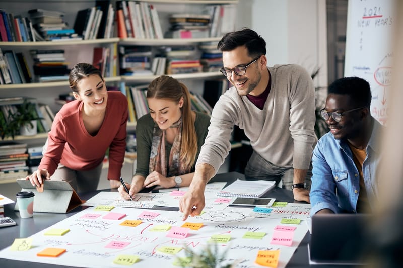 A group of four young professionals brainstorming together
