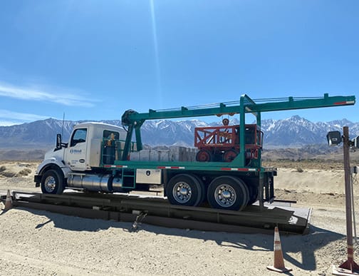 Michelli technician performing a scheduled maintenance inspection on a truck scale deck and load cells