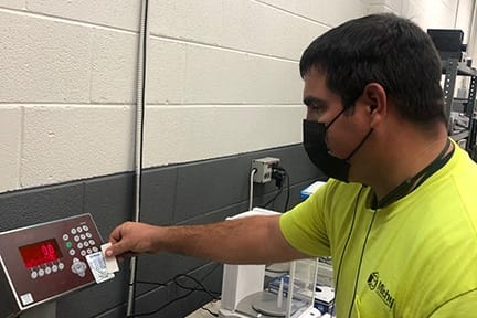 Michelli technician reviewing tolerance and performance readings during a scale maintenance visit