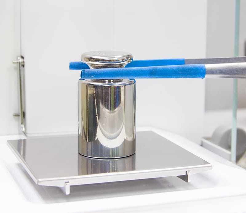 Michelli technician calibrating certified test weights in an ISO/IEC 17025 accredited calibration laboratory
