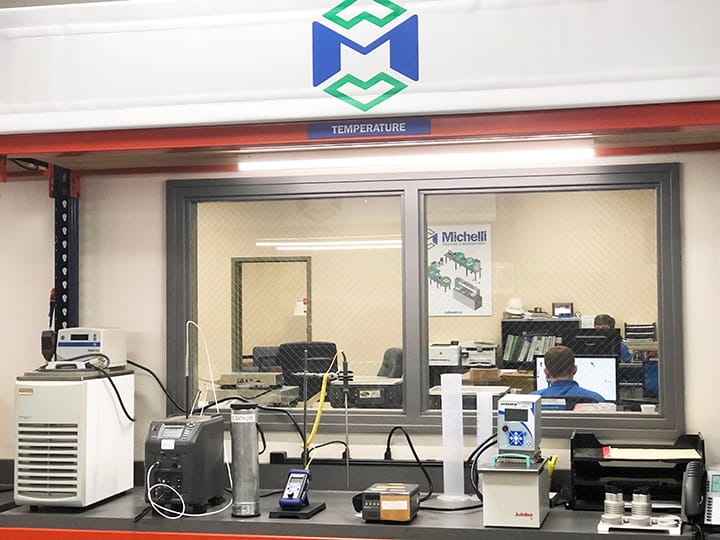 Laboratory with various calibration equipment on a countertop with a viewing window.