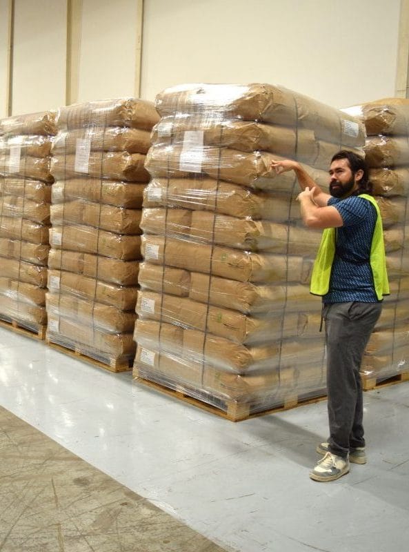 Workers at Green Shutter Tea stand near packaged product