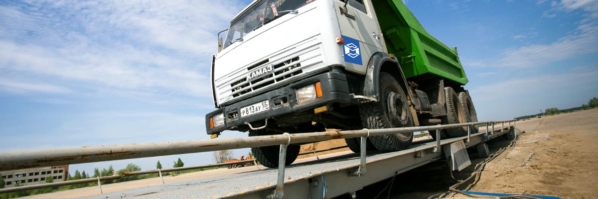 A large dump truck positioned on an industrial truck scale platform demonstrating commercial vehicle weighing