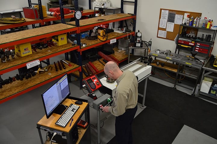 Precision measurement instruments including torque wrenches and dimensional tools on a calibration bench