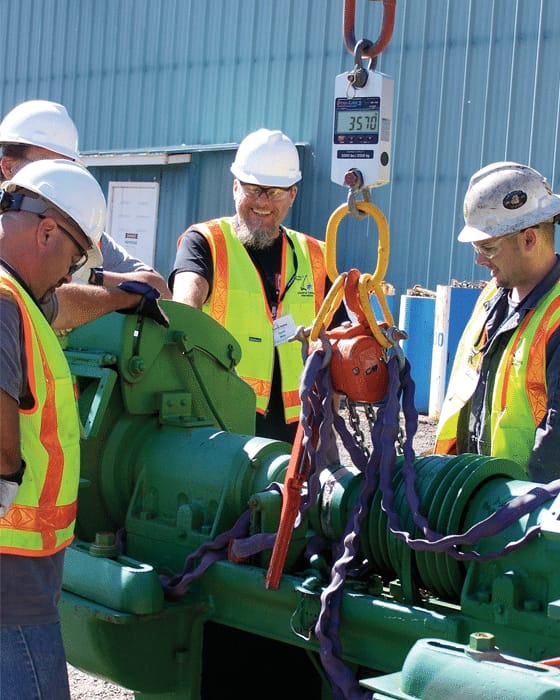 Workers gathered around a Rice Lake Dynamometer during a lifting operation