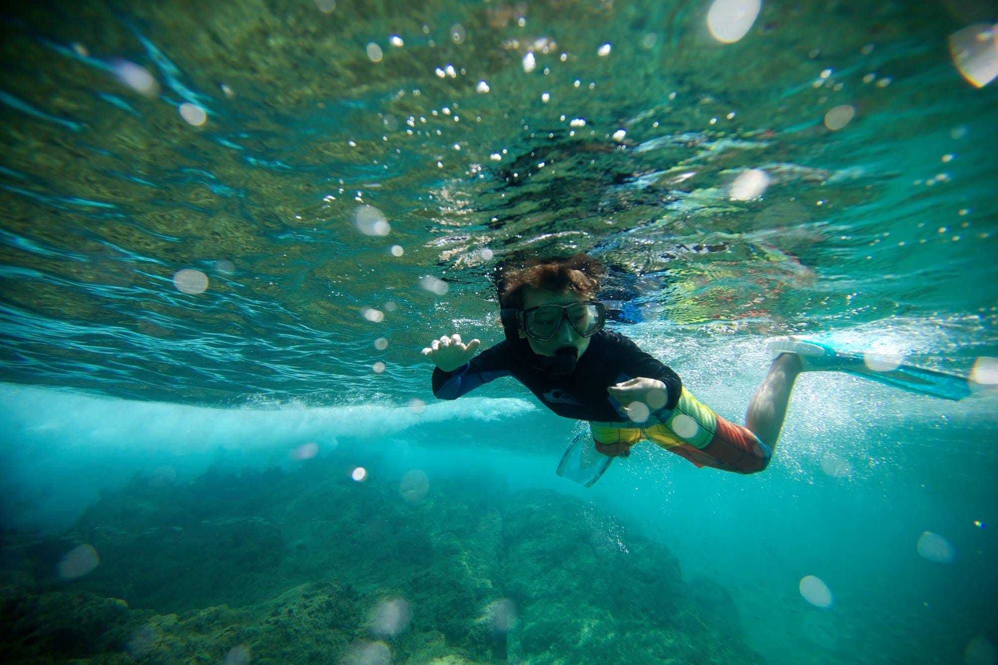 Children snorkeling in the crystal clear waters of Tobago
