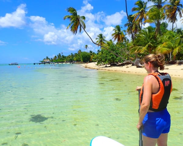 Stand up paddler on crystal clear Caribbean water in Tobago