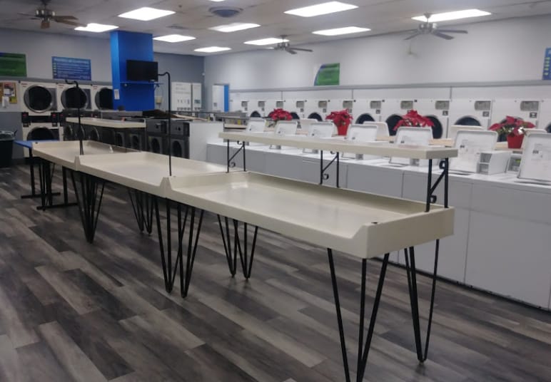Entrum Laundry facility with rows of washers and folding tables