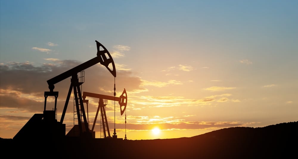 Oil pumpjacks silhouetted against a sunset sky