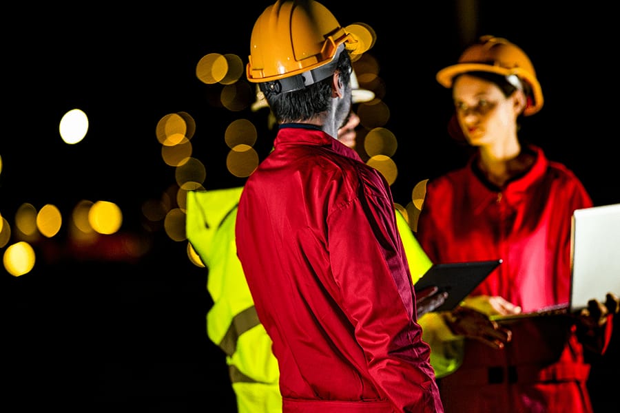Crew members in safety gear coordinating an emergency response at night