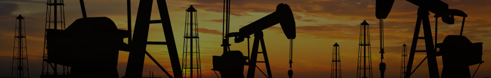 Oil pumpjacks silhouetted against a sunset